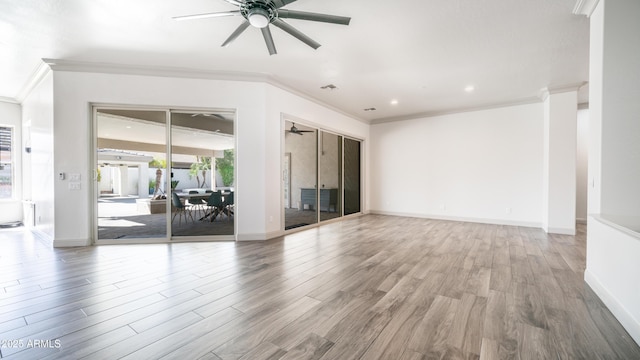 empty room with ornamental molding, ceiling fan, and wood finished floors