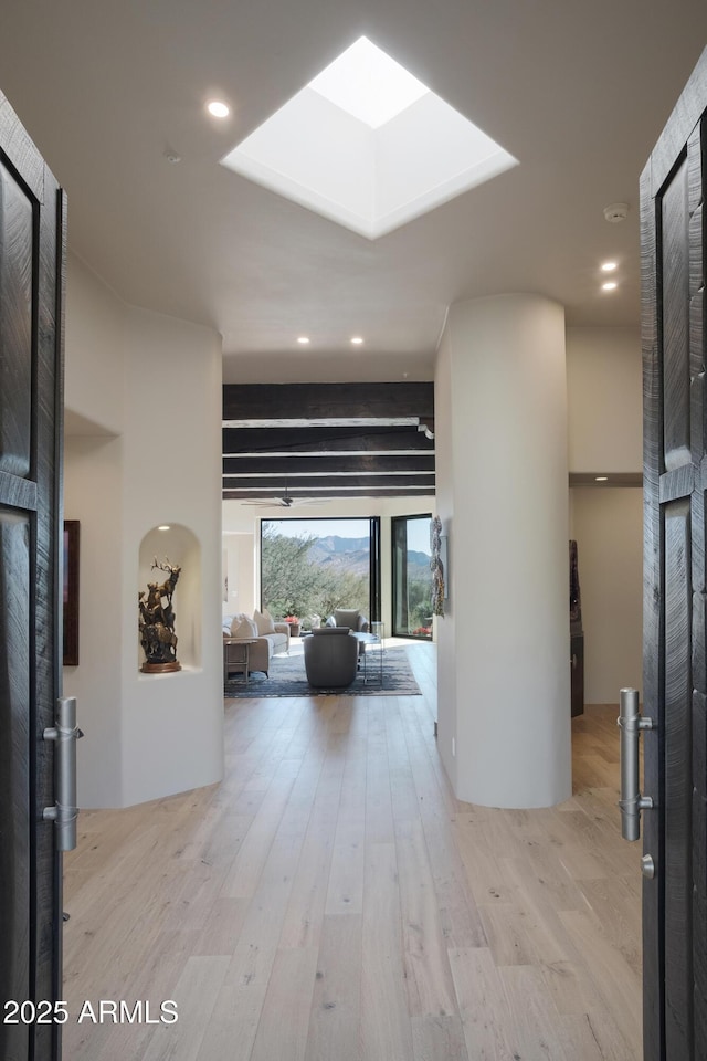 foyer featuring a skylight, light hardwood / wood-style floors, and floor to ceiling windows