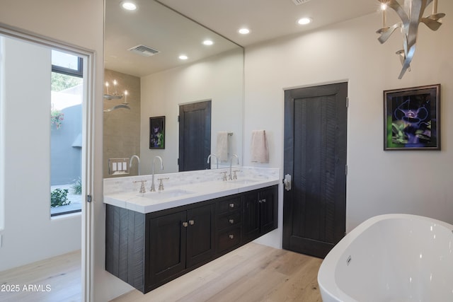 bathroom with a bathing tub, vanity, and hardwood / wood-style floors