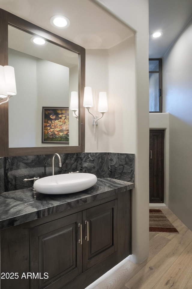 bathroom with tasteful backsplash, vanity, and wood-type flooring