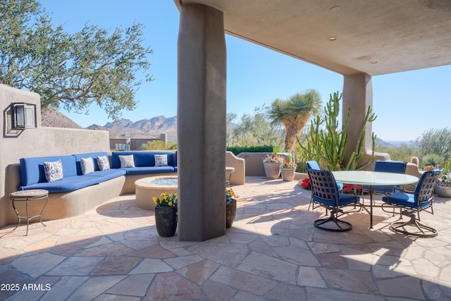 view of patio / terrace featuring an outdoor living space with a fire pit and a mountain view