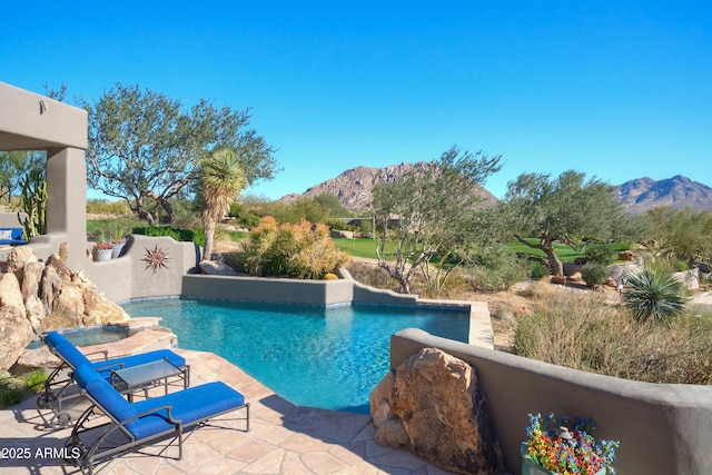 view of swimming pool with a patio and a mountain view