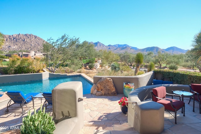 view of swimming pool with a mountain view and a patio area