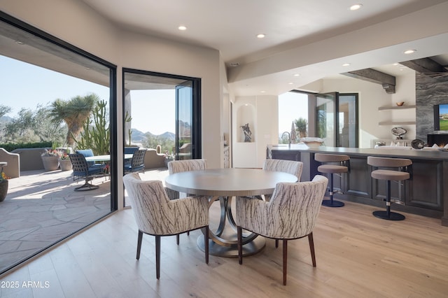 dining area with light wood-type flooring and a mountain view