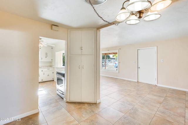 hall with an inviting chandelier and light tile patterned floors