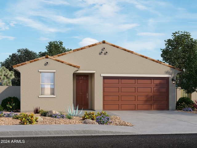 mediterranean / spanish home featuring a garage, a tiled roof, concrete driveway, and stucco siding