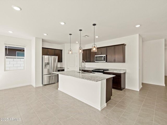 kitchen featuring dark brown cabinetry, pendant lighting, stainless steel appliances, and a sink