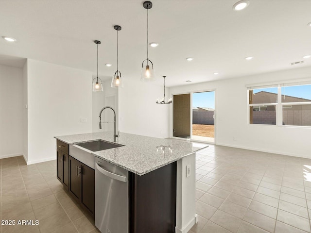 kitchen featuring decorative light fixtures, light stone countertops, a kitchen island with sink, stainless steel dishwasher, and a sink