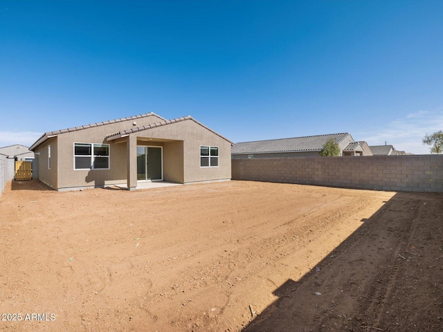 rear view of house with a patio, a fenced backyard, and stucco siding