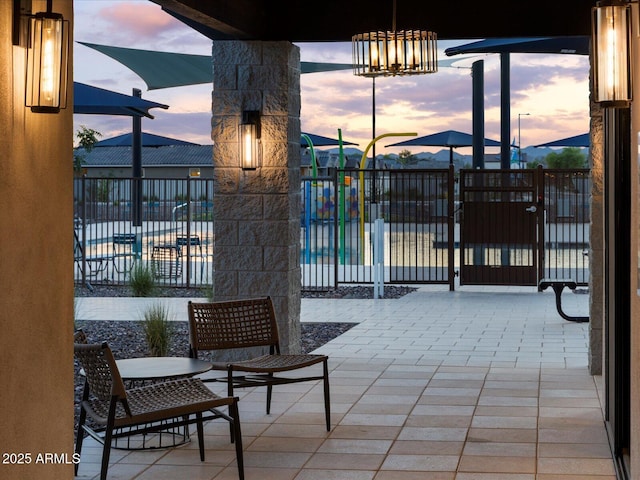 patio terrace at dusk featuring fence