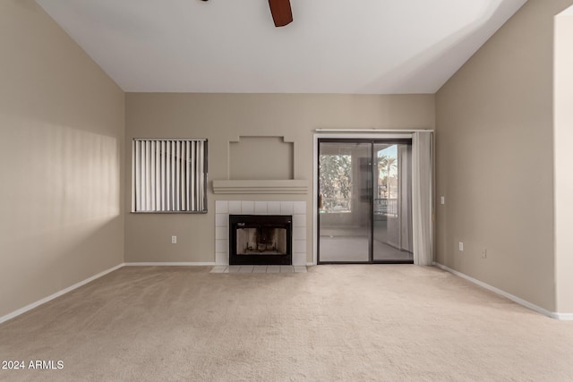 unfurnished living room featuring ceiling fan, light colored carpet, lofted ceiling, and a fireplace