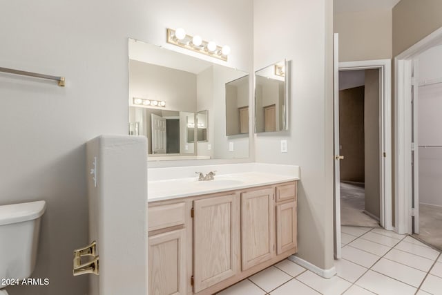 bathroom featuring tile patterned flooring, vanity, and toilet