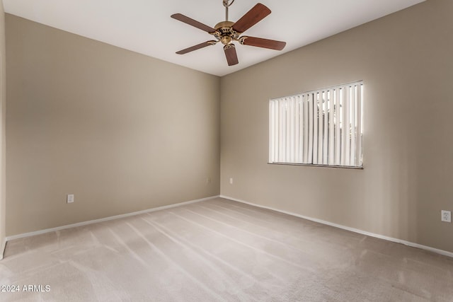 carpeted spare room featuring ceiling fan