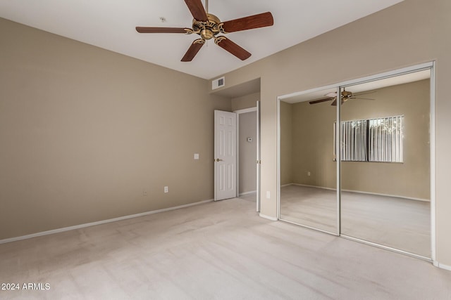 unfurnished bedroom with ceiling fan, light colored carpet, and a closet