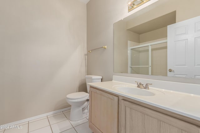 bathroom featuring an enclosed shower, vanity, tile patterned flooring, and toilet