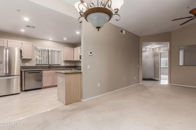 kitchen with white cabinetry, light carpet, appliances with stainless steel finishes, pendant lighting, and ceiling fan with notable chandelier