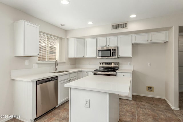 21621 N 48th Pl, Phoenix, AZ 85054 - kitchen with appliances with stainless steel finishes, a sink, a center island, white cabinetry, and visible vents
