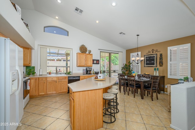 kitchen featuring light countertops, white refrigerator with ice dispenser, a notable chandelier, and visible vents