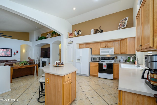 kitchen featuring light tile patterned flooring, white appliances, open floor plan, light countertops, and a sink