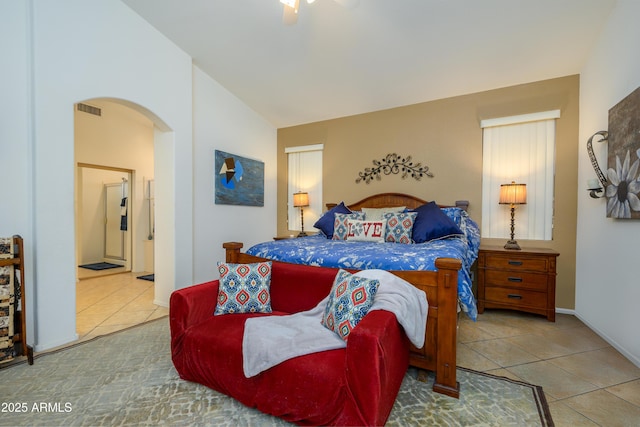 tiled bedroom with visible vents, baseboards, ensuite bathroom, ceiling fan, and arched walkways