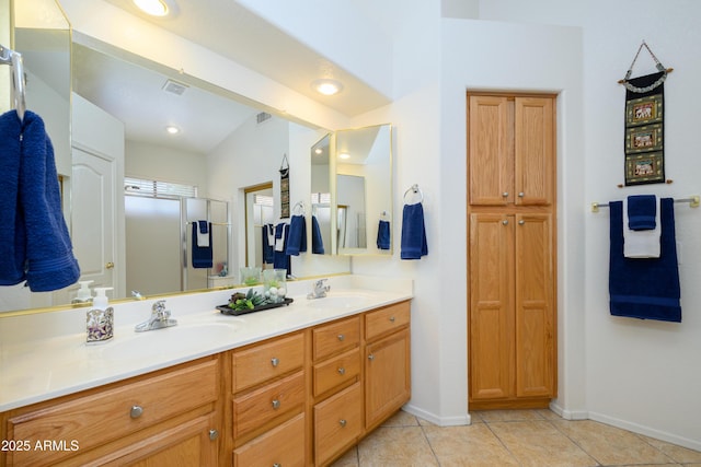 bathroom featuring double vanity, visible vents, a sink, tile patterned floors, and baseboards