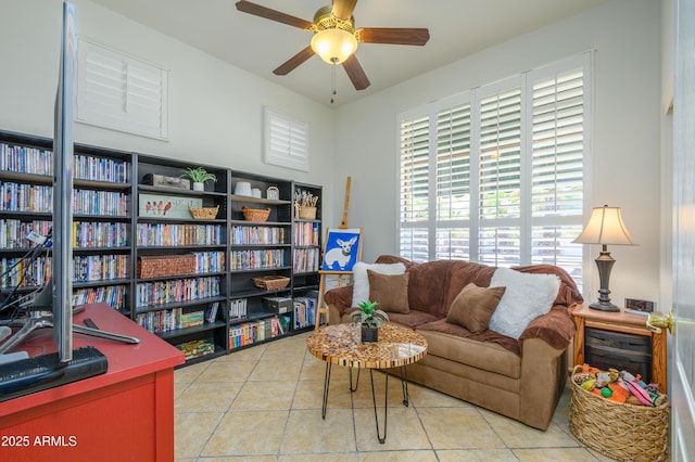 sitting room with a ceiling fan and tile patterned floors