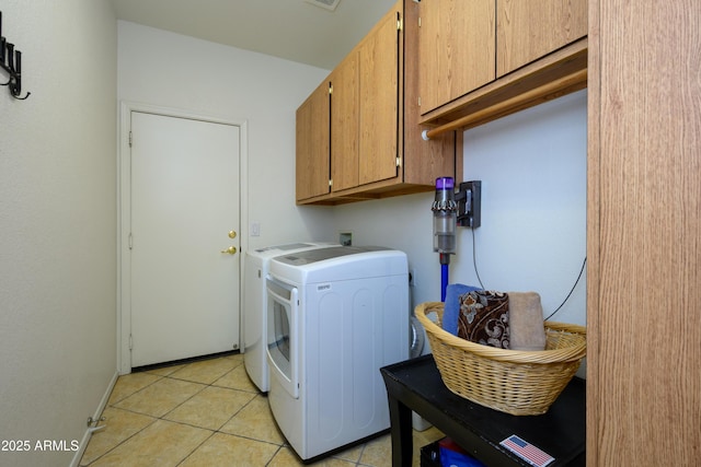 laundry area featuring light tile patterned flooring, cabinet space, and washer and dryer
