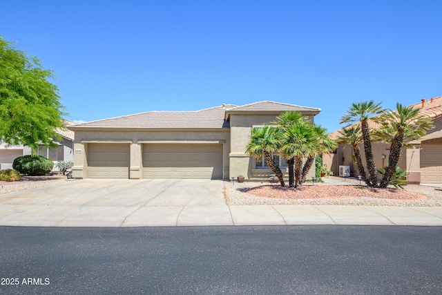 view of front of house featuring an attached garage, driveway, a tile roof, and stucco siding