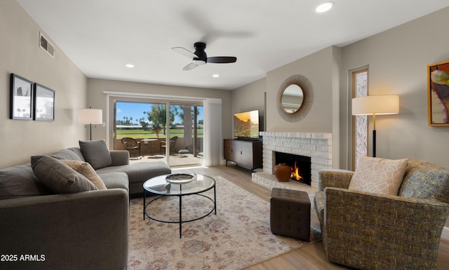 7424 N Via Camello Del Norte Unit 185, Scottsdale, AZ 85258 - living room with wood finished floors, ceiling fan, a fireplace, and recessed lighting
