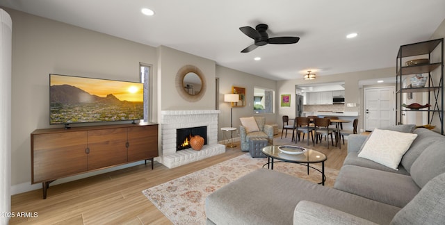 7424 N Via Camello Del Norte Unit 185, Scottsdale, AZ 85258 - living area featuring wood finished floors, a ceiling fan, a brick fireplace, recessed lighting, and baseboards