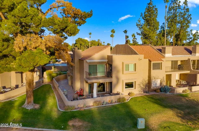 7424 N Via Camello Del Norte Unit 185, Scottsdale, AZ 85258 - back of house featuring a balcony, stucco siding, a chimney, and a tile roof