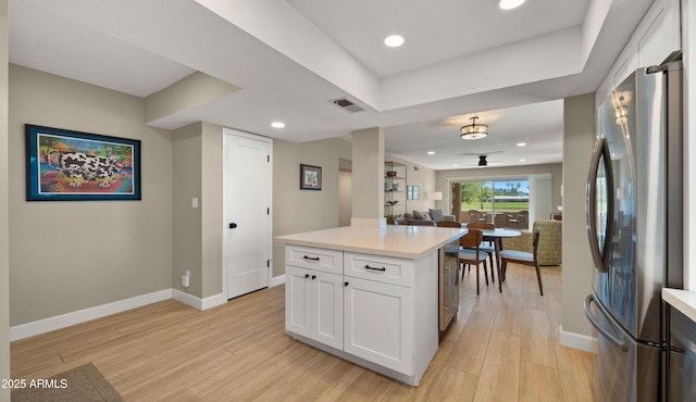 7424 N Via Camello Del Norte Unit 185, Scottsdale, AZ 85258 - kitchen featuring freestanding refrigerator, light countertops, white cabinetry, light wood-style flooring, and baseboards