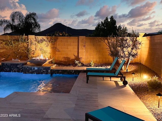 2308 E Dry Wood Rd, Phoenix, AZ 85024 - view of pool with a fire pit, a mountain view, a fenced backyard, a pool, and a patio area