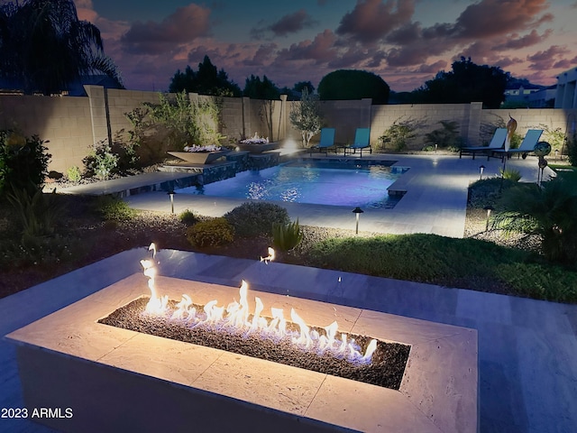 2308 E Dry Wood Rd, Phoenix, AZ 85024 - pool at dusk featuring an outdoor fire pit, a fenced backyard, and a patio area