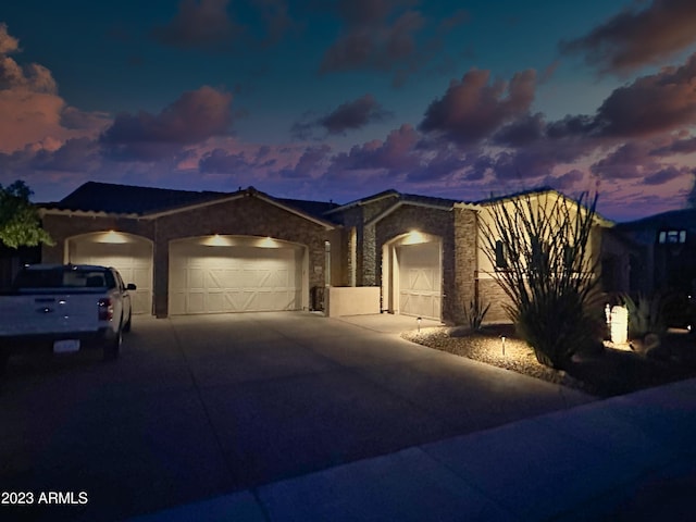 2308 E Dry Wood Rd, Phoenix, AZ 85024 - ranch-style home featuring an attached garage, stone siding, driveway, and stucco siding