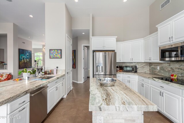 2308 E Dry Wood Rd, Phoenix, AZ 85024 - kitchen featuring stainless steel appliances, a sink, tasteful backsplash, white cabinets, and a high ceiling