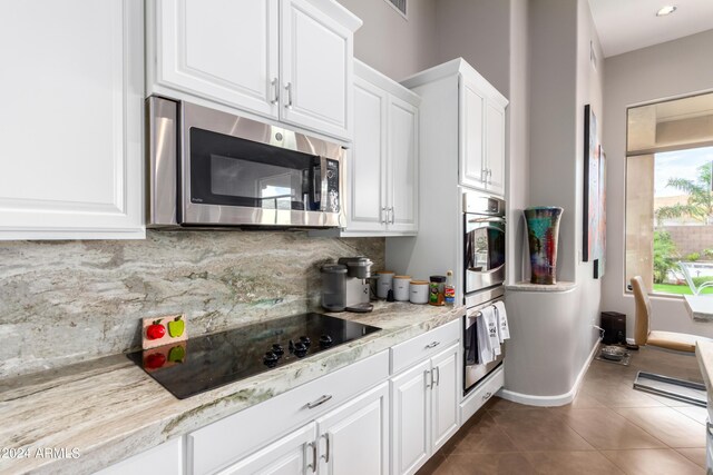 2308 E Dry Wood Rd, Phoenix, AZ 85024 - kitchen featuring stainless steel microwave, decorative backsplash, white cabinetry, baseboards, and dark tile patterned floors