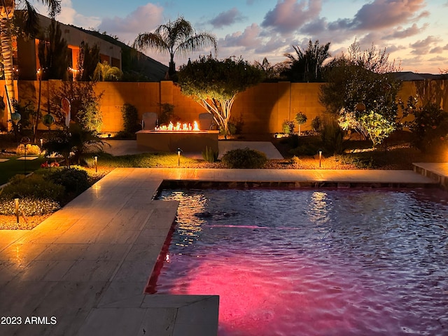 2308 E Dry Wood Rd, Phoenix, AZ 85024 - pool at dusk featuring a patio area, an outdoor fire pit, and a fenced backyard