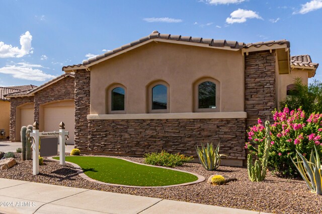 2308 E Dry Wood Rd, Phoenix, AZ 85024 - mediterranean / spanish-style house featuring stone siding, stucco siding, a garage, and a tile roof