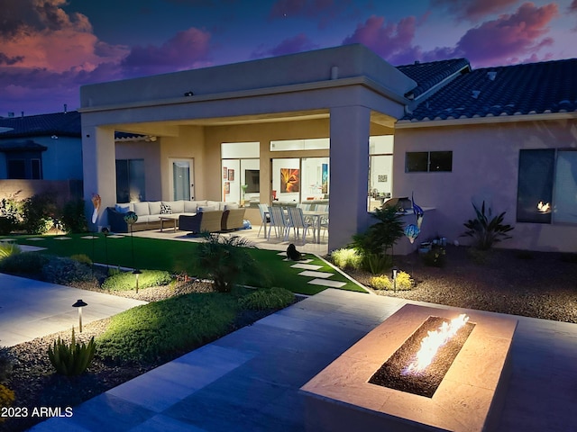 2308 E Dry Wood Rd, Phoenix, AZ 85024 - back of property at dusk featuring an outdoor living space with a fire pit, a patio area, stucco siding, and a tile roof