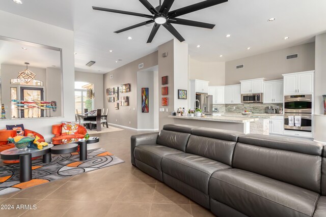 2308 E Dry Wood Rd, Phoenix, AZ 85024 - living room with light tile patterned floors, a towering ceiling, recessed lighting, ceiling fan, and baseboards