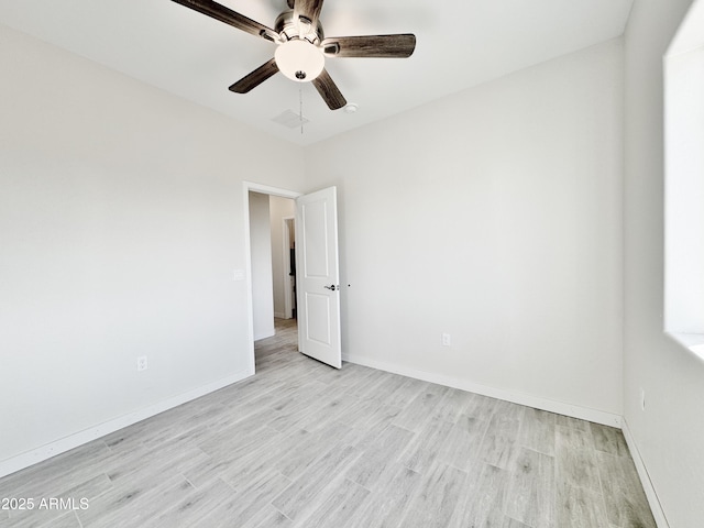 unfurnished room featuring ceiling fan, light wood-style floors, visible vents, and baseboards