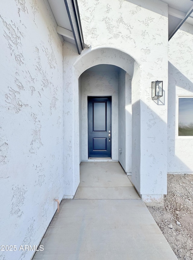 doorway to property featuring stucco siding