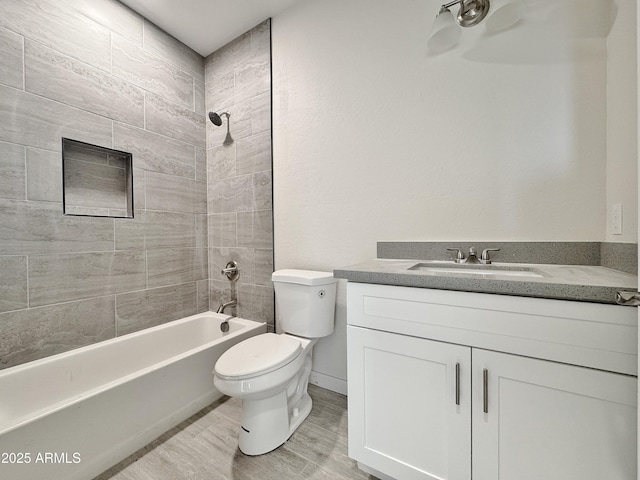 bathroom with toilet,  shower combination, wood finished floors, and vanity