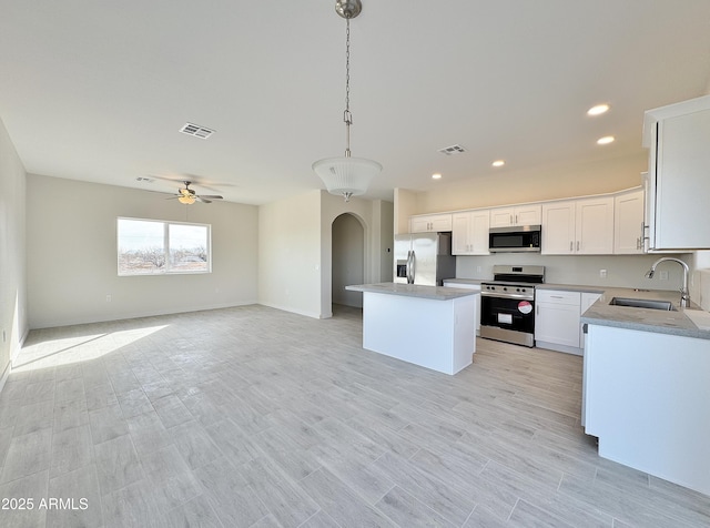 kitchen featuring a sink, stainless steel appliances, arched walkways, and visible vents