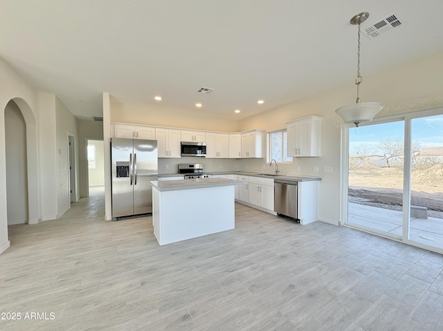 kitchen with visible vents, white cabinets, stainless steel appliances, and a sink