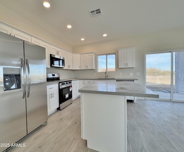 kitchen with visible vents, recessed lighting, stainless steel appliances, white cabinetry, and a sink