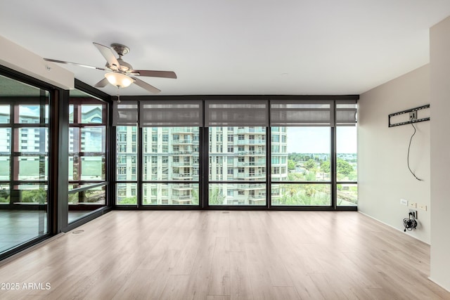 4808 N 24th St Unit 702, Phoenix, AZ 85016 - unfurnished room featuring healthy amount of natural light, wood finished floors, ceiling fan, and floor to ceiling windows