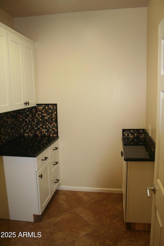 15387 W Columbine Dr, Surprise, AZ 85379 - kitchen featuring white cabinets, dark countertops, baseboards, and backsplash