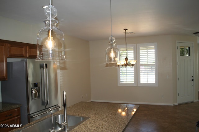 15387 W Columbine Dr, Surprise, AZ 85379 - kitchen featuring dark stone counters, visible vents, a notable chandelier, high end fridge, and brown cabinetry